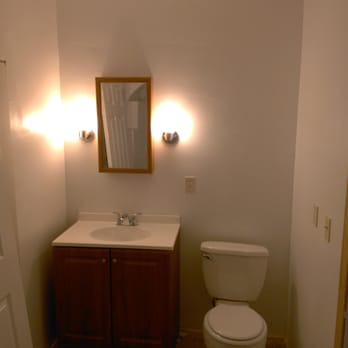 Updated half bath with wood vanity, new lighting and mirror
